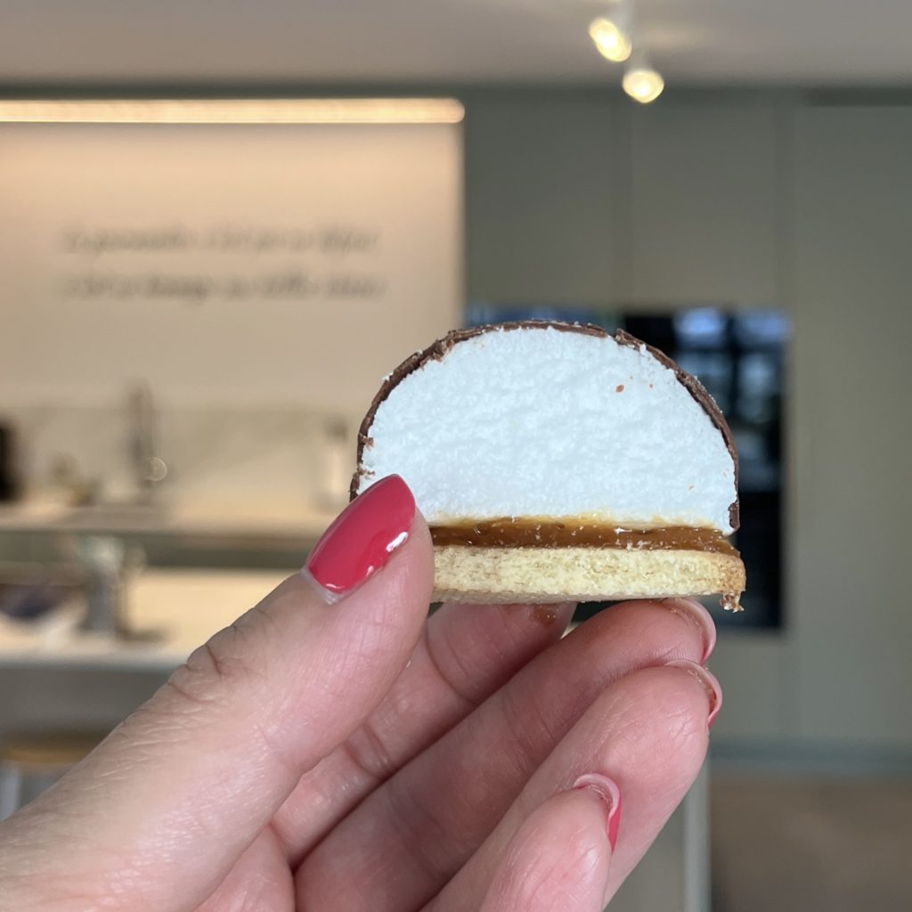 un mélocake coupé que je tiens en main avec la cuisine de l'atelier en arrière-plan