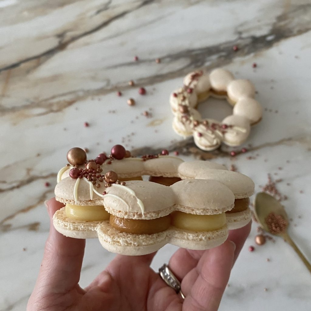 Couronne de macarons beiges au caramel beurre salé et à la ganache passion